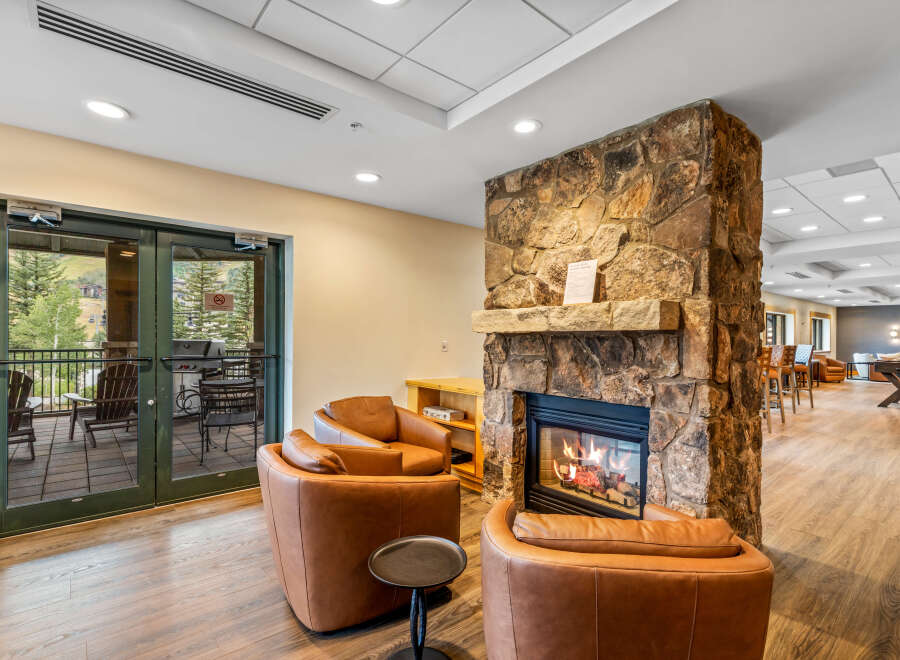 Cozy up by the natural stone fireplace in this inviting living space, perfect for relaxing after a day of outdoor adventures.