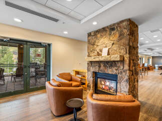 Cozy up by the natural stone fireplace in this inviting living space, perfect for relaxing after a day of outdoor adventures.