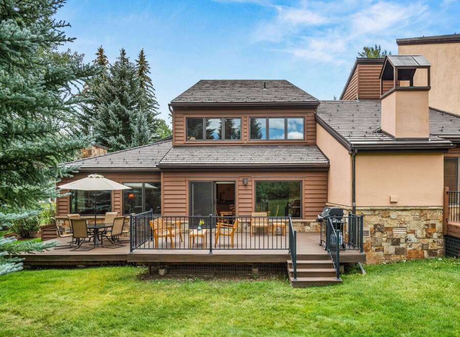 Enjoy outdoor living with this spacious deck featuring a dining set and lounge chairs, perfect for entertaining.
