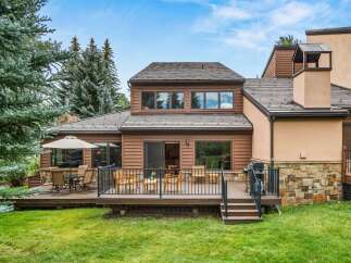 Enjoy outdoor living with this spacious deck featuring a dining set and lounge chairs, perfect for entertaining.