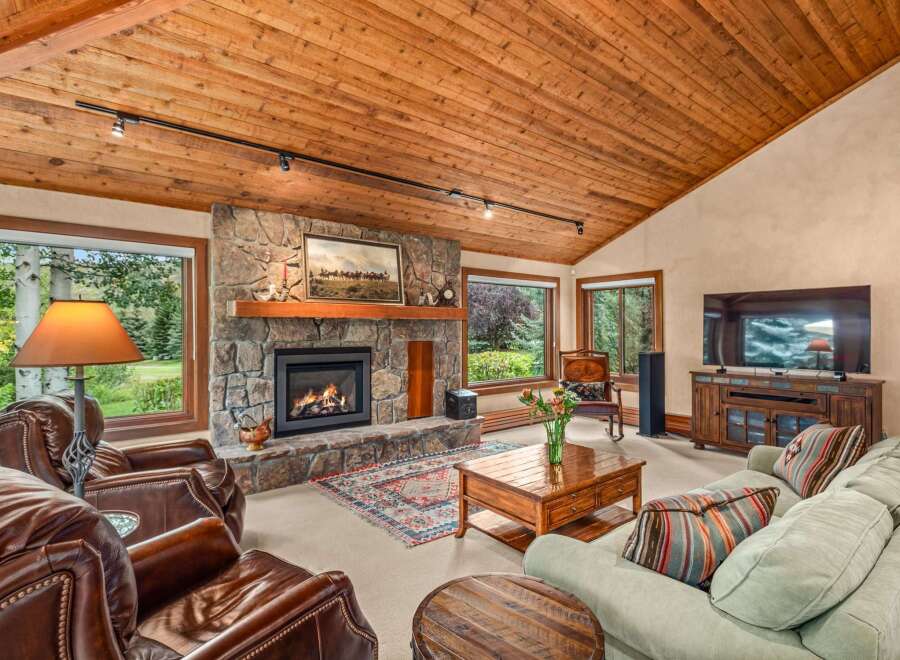 Experience rustic charm in this inviting living room, featuring a magnificent stone fireplace as the centerpiece.