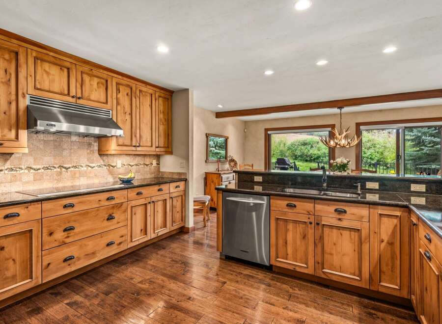 Experience rustic charm in this spacious kitchen featuring custom knotty pine cabinetry and granite countertops.
