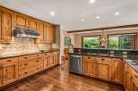 Experience rustic charm in this spacious kitchen featuring custom knotty pine cabinetry and granite countertops.