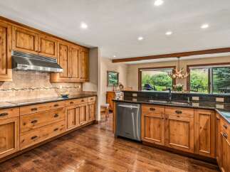 Experience rustic charm in this spacious kitchen featuring custom knotty pine cabinetry and granite countertops.
