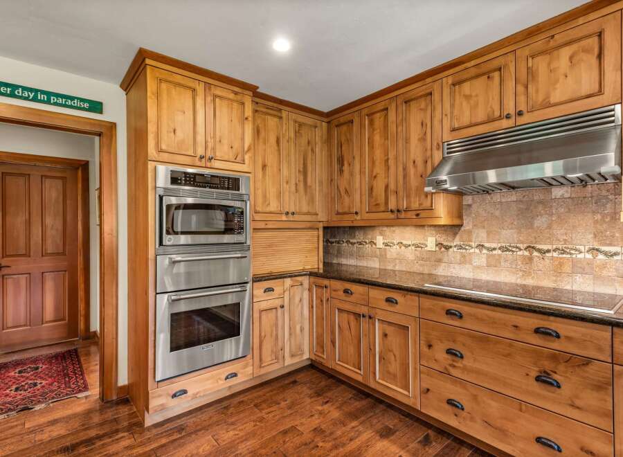 Experience rustic charm in this beautifully appointed kitchen, featuring custom knotty alder cabinetry and sleek stainless steel appliances.