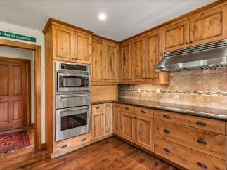 Experience rustic charm in this beautifully appointed kitchen, featuring custom knotty alder cabinetry and sleek stainless steel appliances.