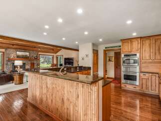 Experience rustic charm and modern convenience in this spacious kitchen and living area.