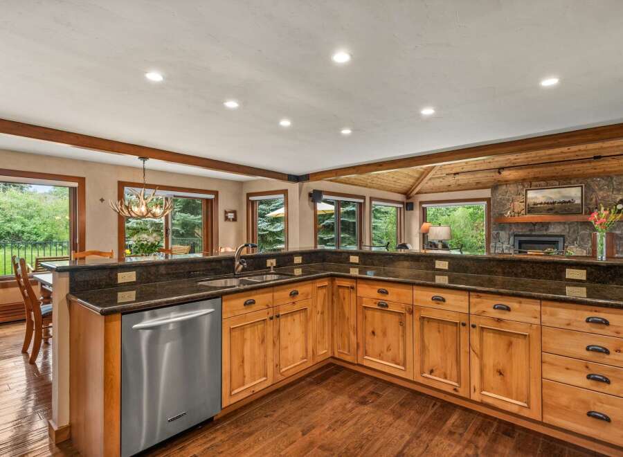 Experience rustic charm in this spacious kitchen, featuring warm wood cabinetry and granite countertops.