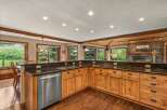 Experience rustic charm in this spacious kitchen, featuring warm wood cabinetry and granite countertops.