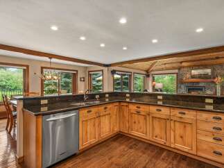 Experience rustic charm in this spacious kitchen, featuring warm wood cabinetry and granite countertops.