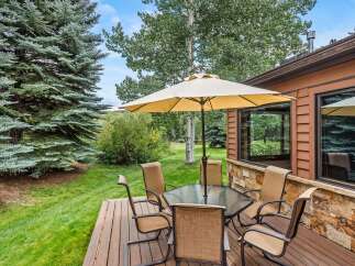 Enjoy outdoor living on this charming deck, complete with a glass-top dining table and comfortable seating, perfect for al fresco meals.