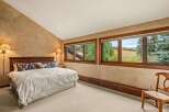 Experience serene mountain living in this charming bedroom, featuring a plush king-size bed adorned with decorative pillows and a cozy duvet.