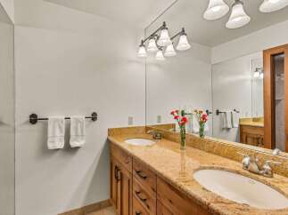 This luxurious bathroom features a double vanity with granite countertops and undermount sinks, perfect for a busy household.
