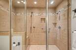 Step into this luxurious walk-in shower, featuring elegant tiled walls and a built-in bench for ultimate comfort.
