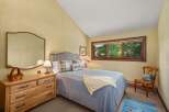 This charming bedroom features a comfortable queen-size bed with a plush quilted coverlet and decorative pillows.
