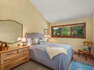 This charming bedroom features a comfortable queen-size bed with a plush quilted coverlet and decorative pillows.