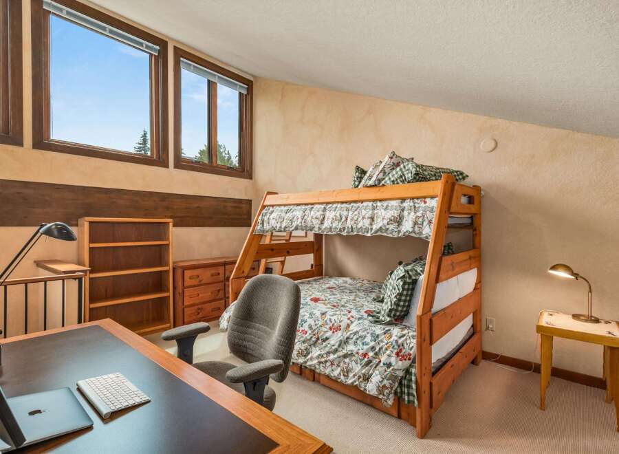 This charming bedroom features a cozy bunk bed with floral bedding, perfect for accommodating guests or children.