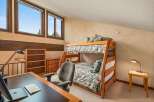 This charming bedroom features a cozy bunk bed with floral bedding, perfect for accommodating guests or children.