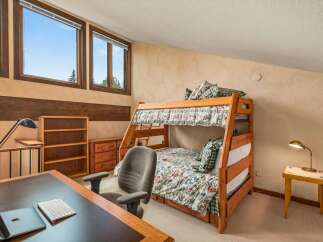 This charming bedroom features a cozy bunk bed with floral bedding, perfect for accommodating guests or children.