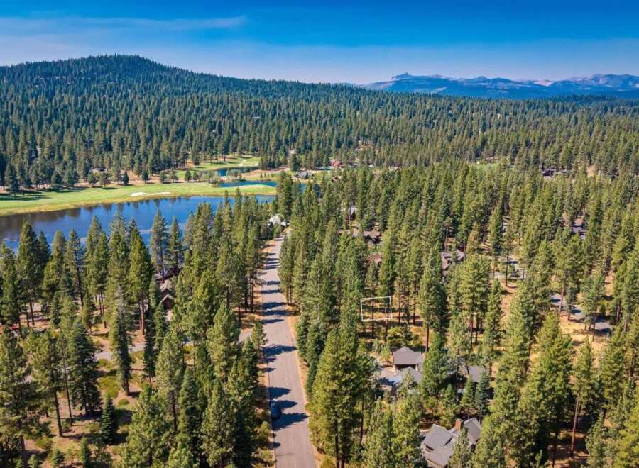 Nestled amidst a dense pine forest, this property offers a serene retreat with a picturesque lake and golf course views.