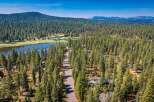Nestled amidst a dense pine forest, this property offers a serene retreat with a picturesque lake and golf course views.