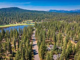 Nestled amidst a dense pine forest, this property offers a serene retreat with a picturesque lake and golf course views.