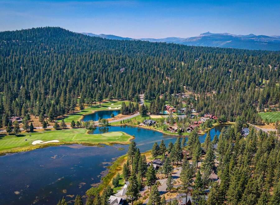 Experience luxury living amidst a stunning natural landscape with this aerial view of a golf course community.