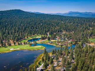 Experience luxury living amidst a stunning natural landscape with this aerial view of a golf course community.