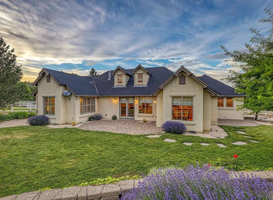 This stunning home features a spacious backyard with a paved patio, perfect for outdoor entertaining.