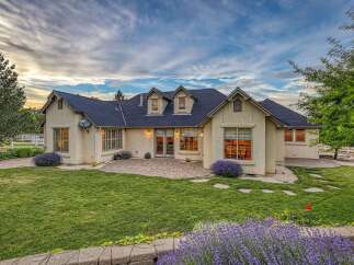 This stunning home features a spacious backyard with a paved patio, perfect for outdoor entertaining.