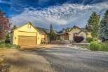 This stunning home boasts a welcoming facade with a large driveway leading to a spacious three-car garage.