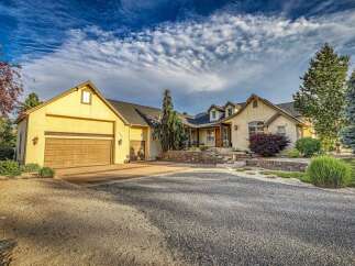 This stunning home boasts a welcoming facade with a large driveway leading to a spacious three-car garage.