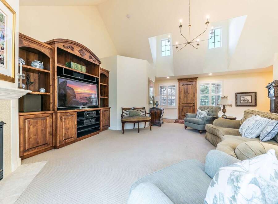 Step into this inviting living room featuring a grand entertainment center with ample storage and a large television, perfect for cozy movie nights.