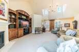Step into this inviting living room featuring a grand entertainment center with ample storage and a large television, perfect for cozy movie nights.