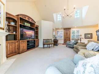 Step into this inviting living room featuring a grand entertainment center with ample storage and a large television, perfect for cozy movie nights.