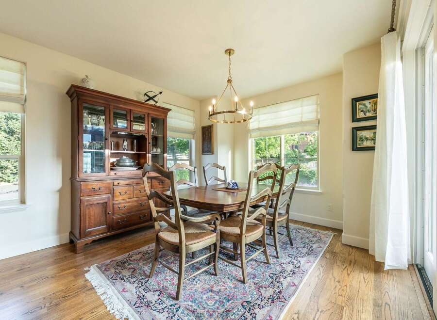 This elegant dining room features a classic wooden hutch and a matching dining table with six chairs, all set on a beautiful oriental rug.