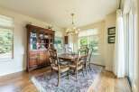 This elegant dining room features a classic wooden hutch and a matching dining table with six chairs, all set on a beautiful oriental rug.