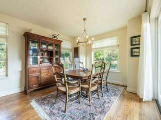 This elegant dining room features a classic wooden hutch and a matching dining table with six chairs, all set on a beautiful oriental rug.