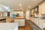 This spacious kitchen boasts a large butcher block island with a sink, perfect for meal preparation and casual dining.