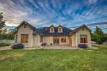 This stunning home features a beautifully manicured lawn and a charming patio area, perfect for outdoor entertaining.