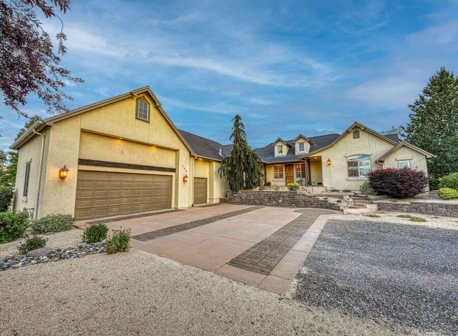 Discover this stunning home featuring a spacious driveway with decorative brick inlays, leading to a large garage.