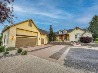 Discover this stunning home featuring a spacious driveway with decorative brick inlays, leading to a large garage.