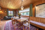 Experience cozy living in this charming dining area, featuring a rustic wooden table adorned with a vibrant floral centerpiece.