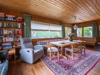 This cozy dining area features a rustic wooden table surrounded by four chairs, perfect for intimate meals.