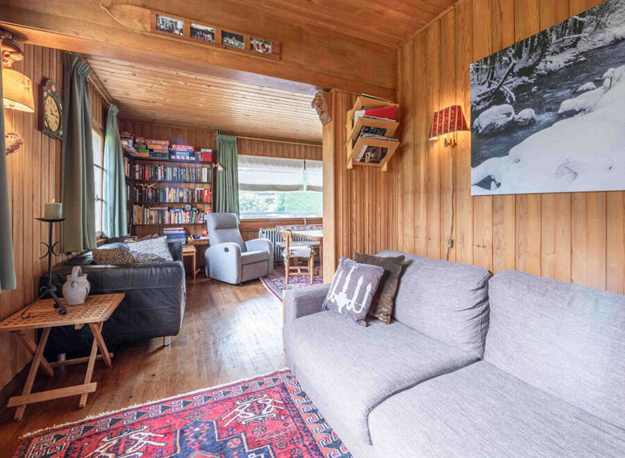 Step into a cozy living room featuring warm wood paneling throughout, creating a rustic and inviting atmosphere.