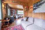 Step into a cozy living room featuring warm wood paneling throughout, creating a rustic and inviting atmosphere.