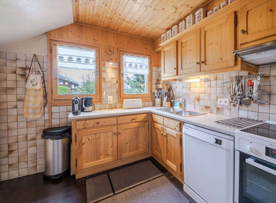Charming alpine kitchen featuring warm wooden cabinetry and a cozy, rustic aesthetic.