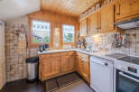 Charming alpine kitchen featuring warm wooden cabinetry and a cozy, rustic aesthetic.