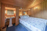 This charming bedroom features a cozy bed with a floral-patterned duvet, perfect for a restful night's sleep.