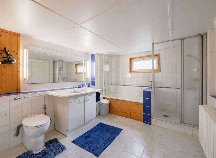 This bright and functional bathroom features a spacious vanity with ample storage, a comfortable toilet, and a separate shower stall.